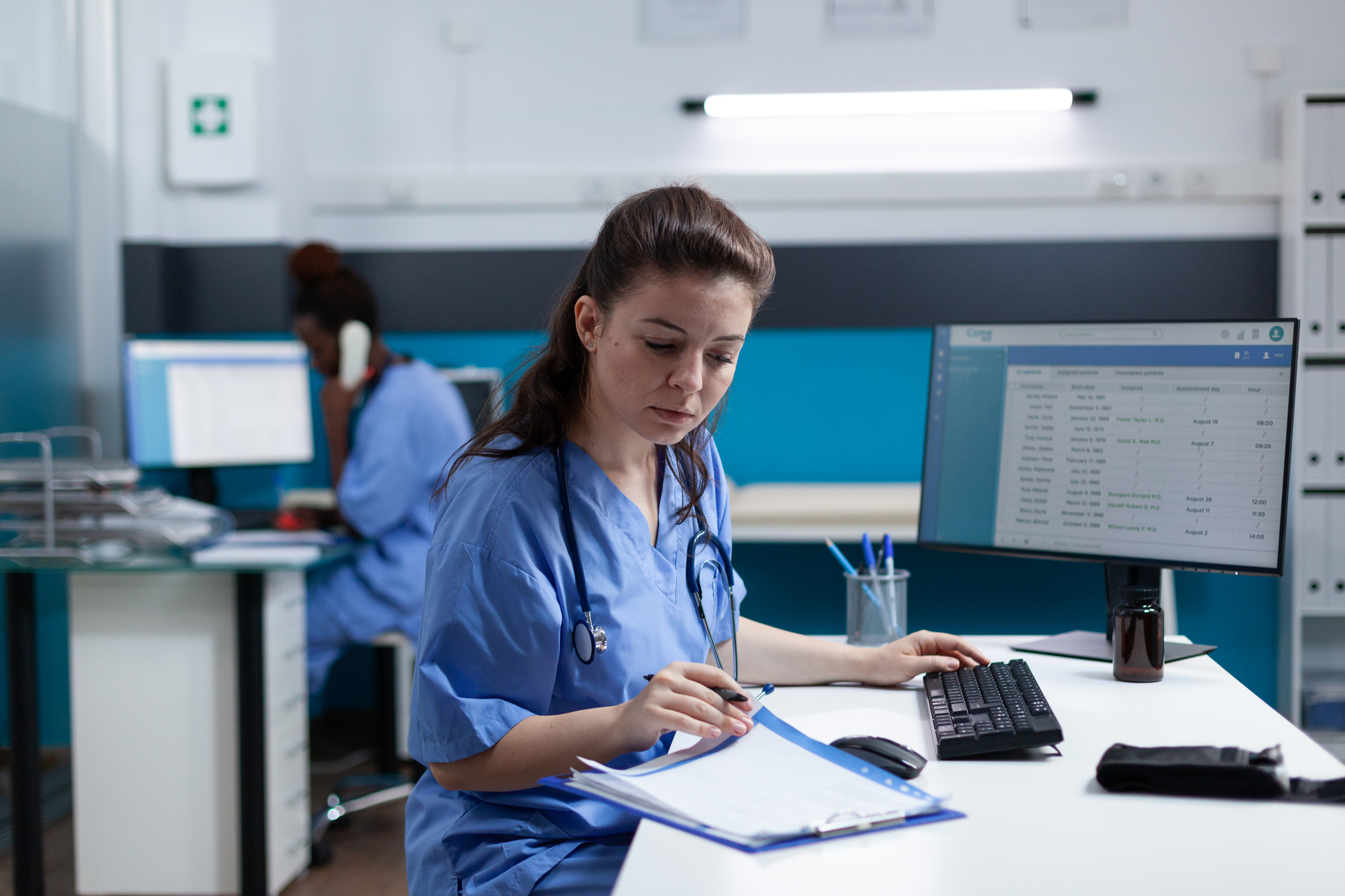 Pharmacist nurse with stethoscope analyzing healthcare treatment on medical documents typing sickness expertise working in hospital examination office. Woman asisstance checking disease results